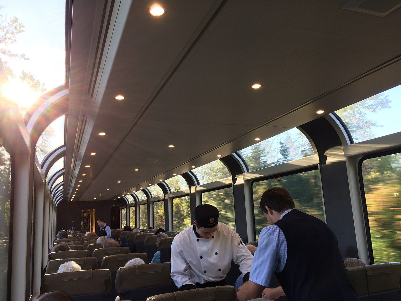 Inside a SilverLeaf coach, with oversized panoramic windows and hosts serving guests at their seats